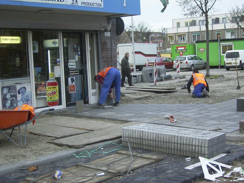 22-11-2004 de stratenmakers zijn nu bezig van het bestraten van dikke tegels voor de op en af ritten van de parkeer plaats naar de noord/zuid verbinding.