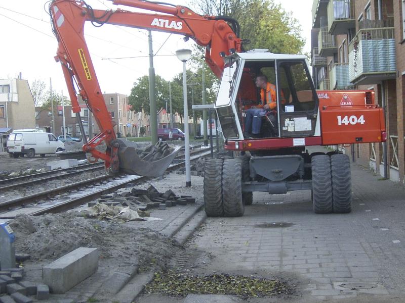 25-10-2004 hier is de kraanmachinist bezig de stenen weg te halen bij de tramhalte rhijnauwensingel die word binnen kort vervangen.