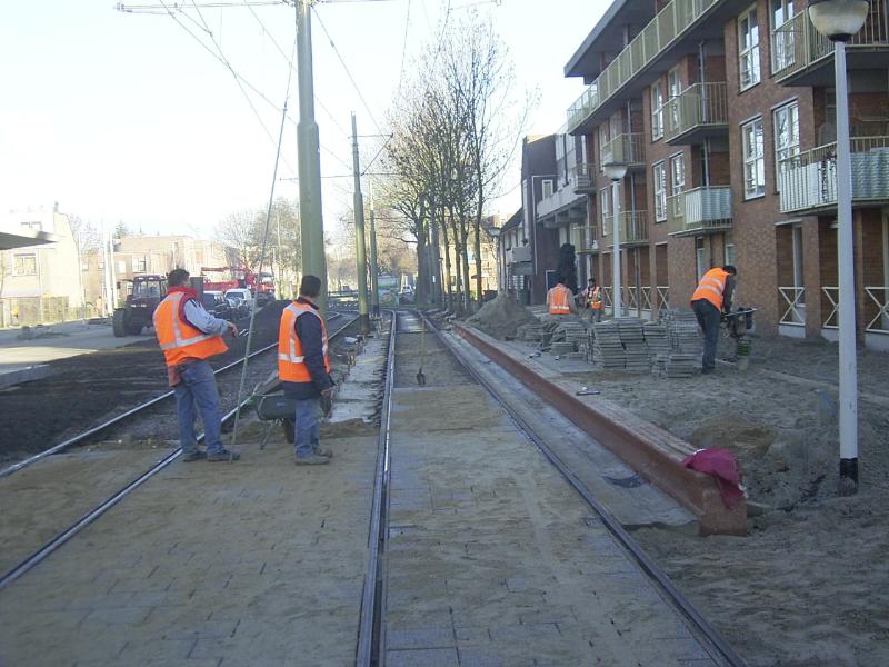 03-12-2004  de straatmakers zijn hier bezig aan het bestraten van het (perron)tramhalte en ook tussen de tramrails  op de noord/zuid verbinding.
