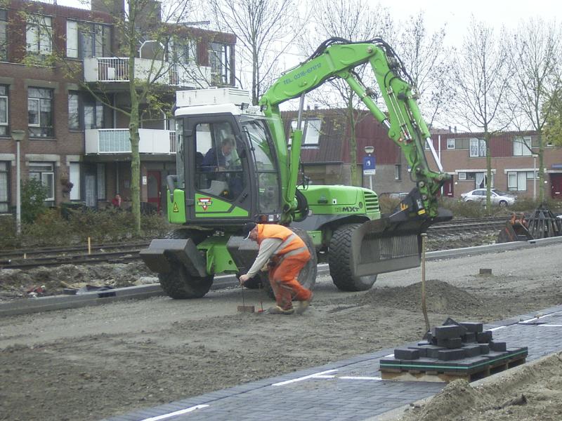 23-10-2004 de grondwerker is hier bezig de hoogte te bepalen voor het asfalt.