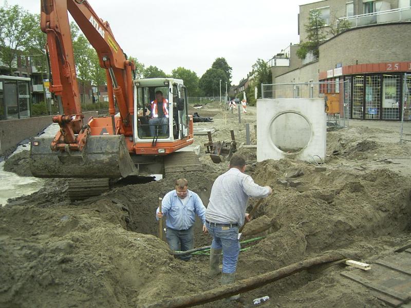 05-10-2004 de grondwerkers zijn bezig om de kabels vrij te maken zodat de rioolbuis er onderdoor kan en aangesloten op het bestaande riool.