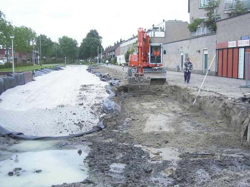 22-09-2004 de kraanmachinist is bezig om het laatste stuk geul voor de riolering weg te graven zodat het riool er in gelegen kan worden.