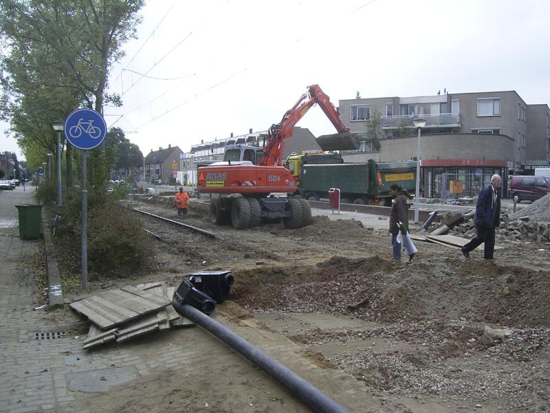 16-10-2004 de kraanmachinist is bezig het grind tussen de trambaan weg te halen en in de wagen te kiepen.