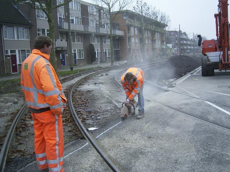 30-11-2004 hier zijn de mensen van bruil bezig om een strook asfalt weer weg te halen daar moet een tegel rand voor in de plaats komen.