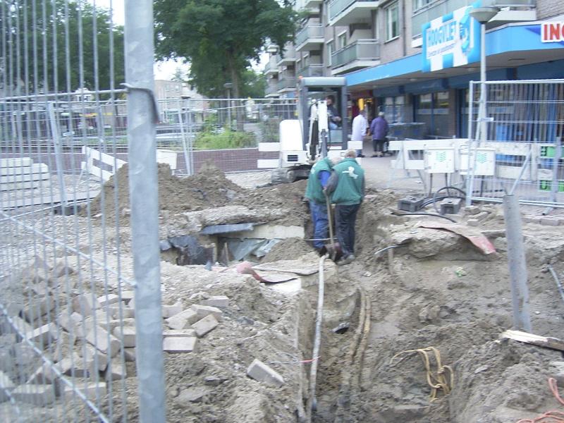 22-09-2004 grondwerkers zijn bezig om de bekabeling en de leidingen vrij te maken om het riool aan te kunnen sluiten.