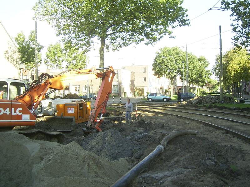 07-10-2004 de kraanmachinist is bezig om een geul te graven zodat de nieuwe rioolbuis kan worden aangesloten .