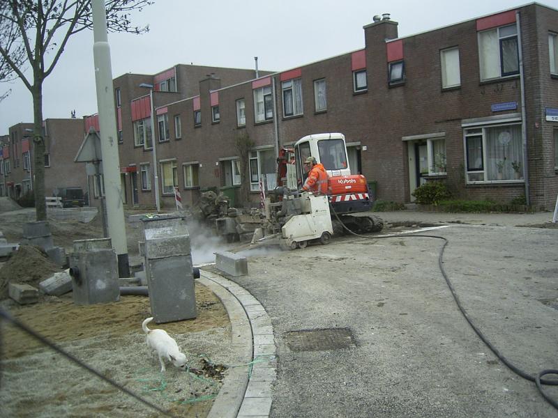 01-12-2004 de betonzager is hier aan de schinnenbaan het asfalt aan het doorzagen aan de schinnenbaan.
