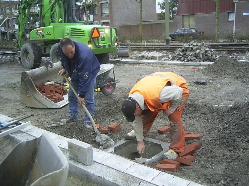 23-10-2004 de grondwerker is hier bezig met stenen te metselen de put moet nog iets omhoog.