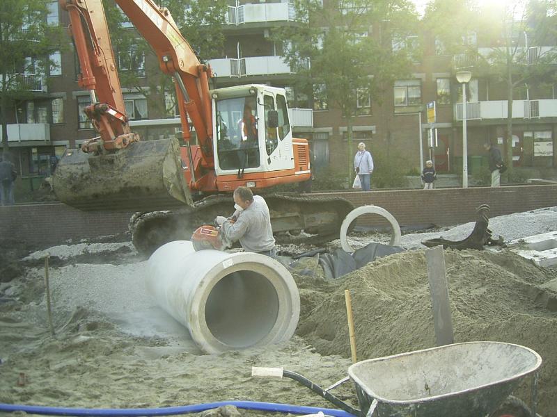 06-10-2004 de grondwerker is bezig om de rioolbuis op maat te zagen .