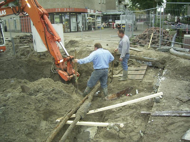 05-10-2004 de grondwerkers zijn bezig om de kabels vrij te maken zodat de rioolbuis er onderdoor kan en aangesloten op het bestaande riool.