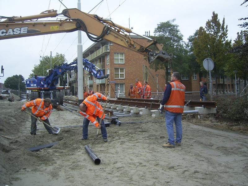 16-10-2004 de r.e.t mensen zijn bezig een bekabelingbuis af te dekken met zand en het plaatsen van een tramrails.